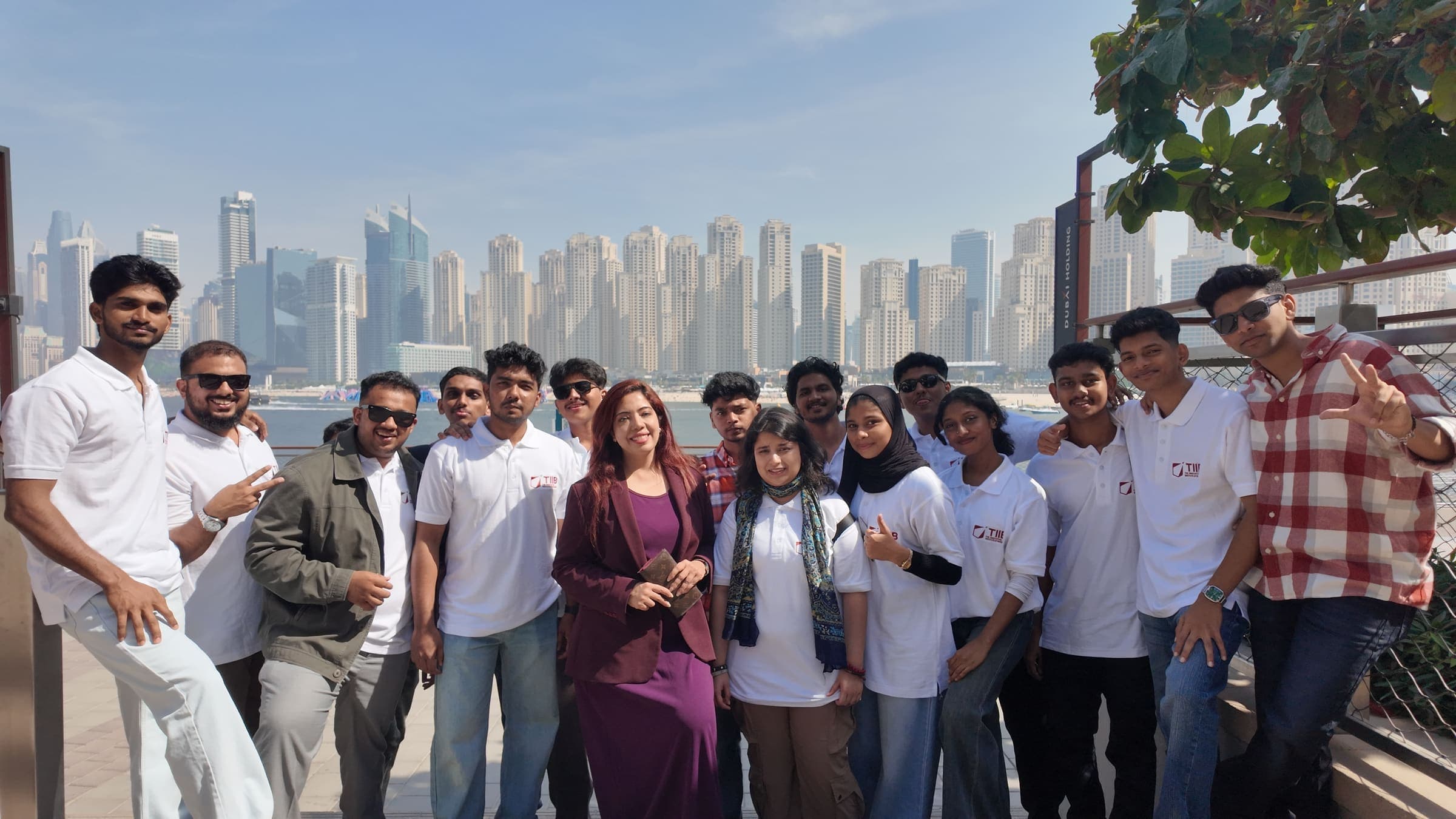 TIIB students together on the waterfront, with the Dubai Marina towers behind them