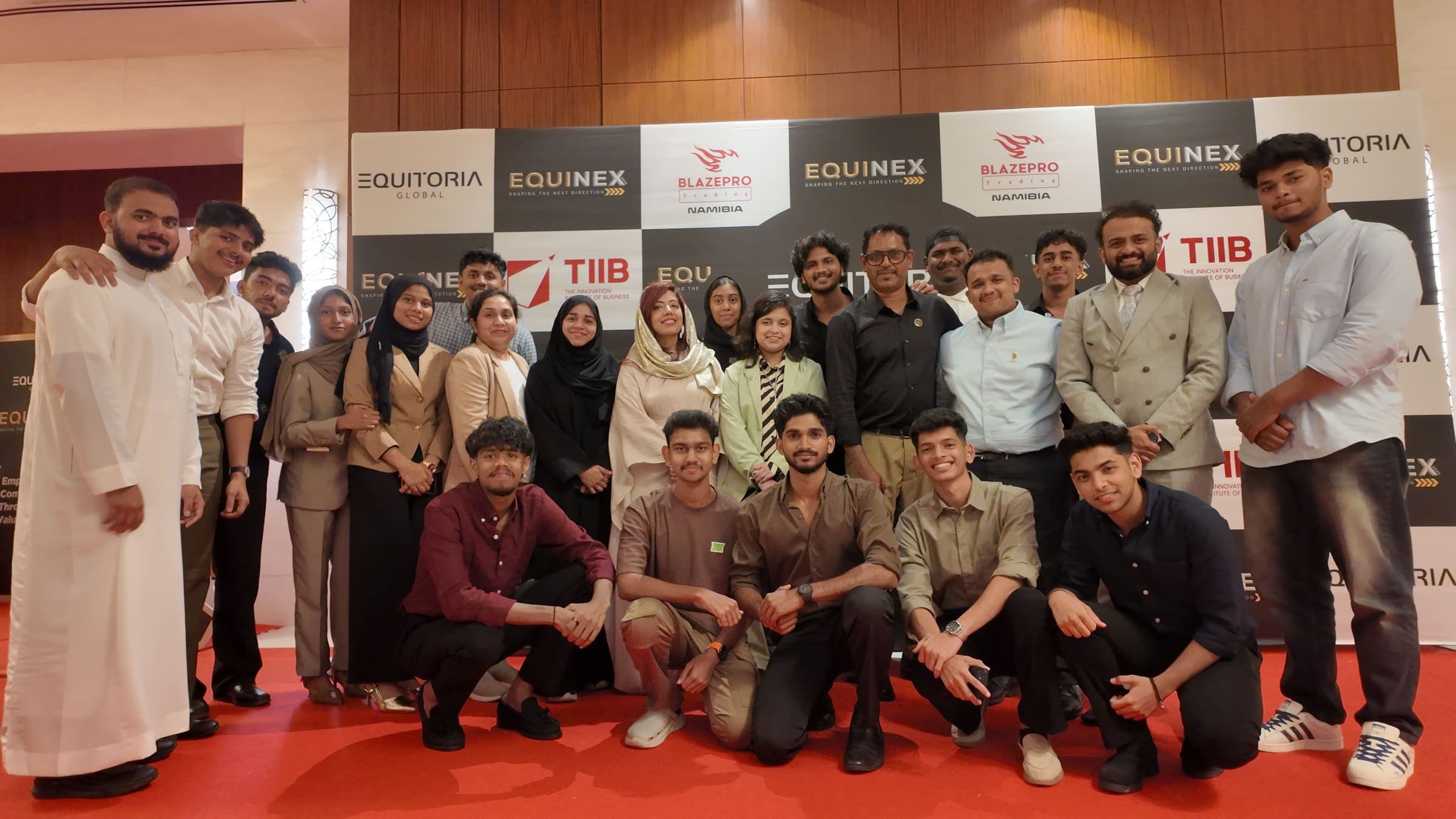 Students and staff in front of the sponsor board at the Equinex event