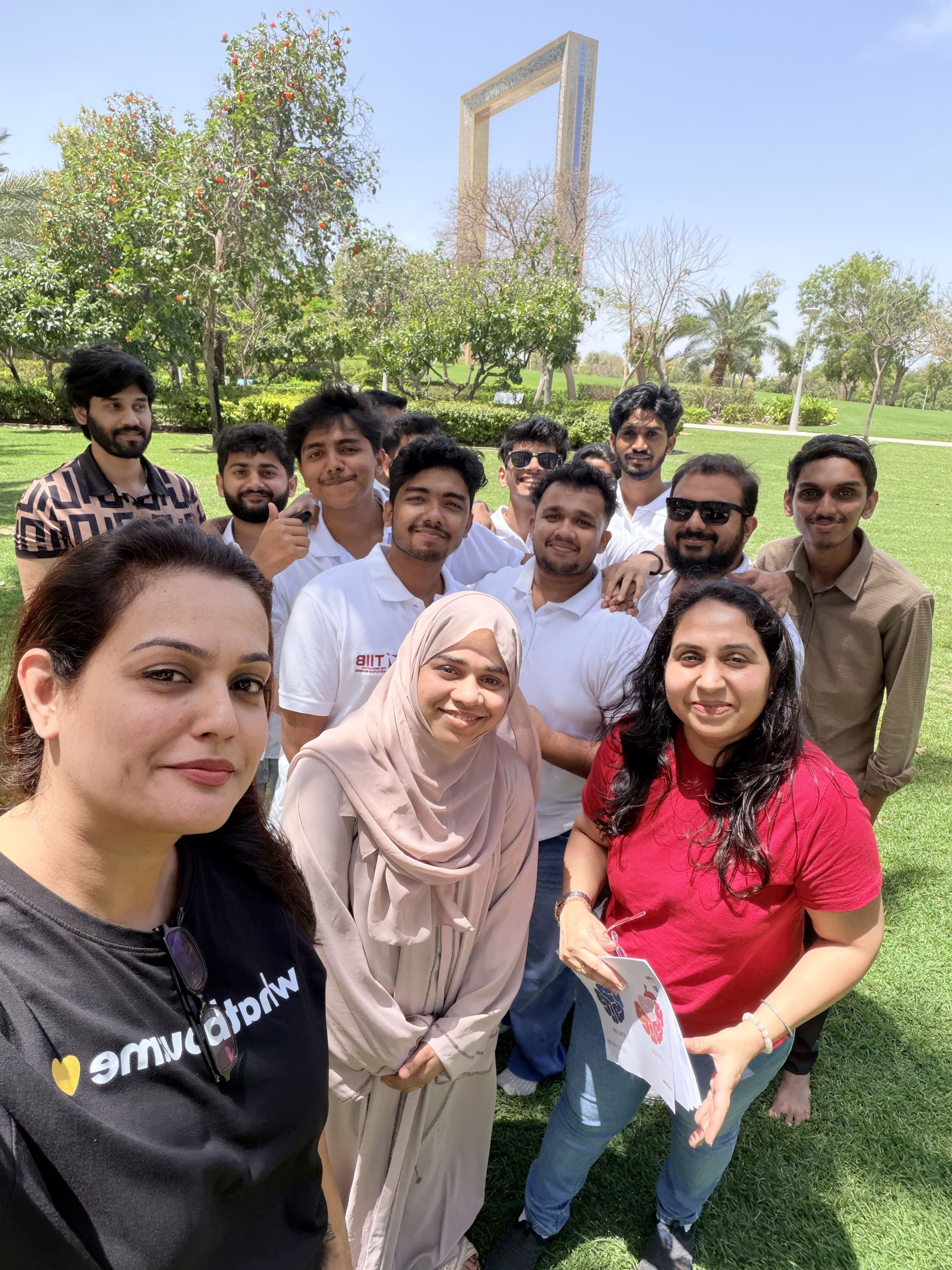 A group of students and staff on a visit to Zabeel Park, with the Dubai Frame behind them