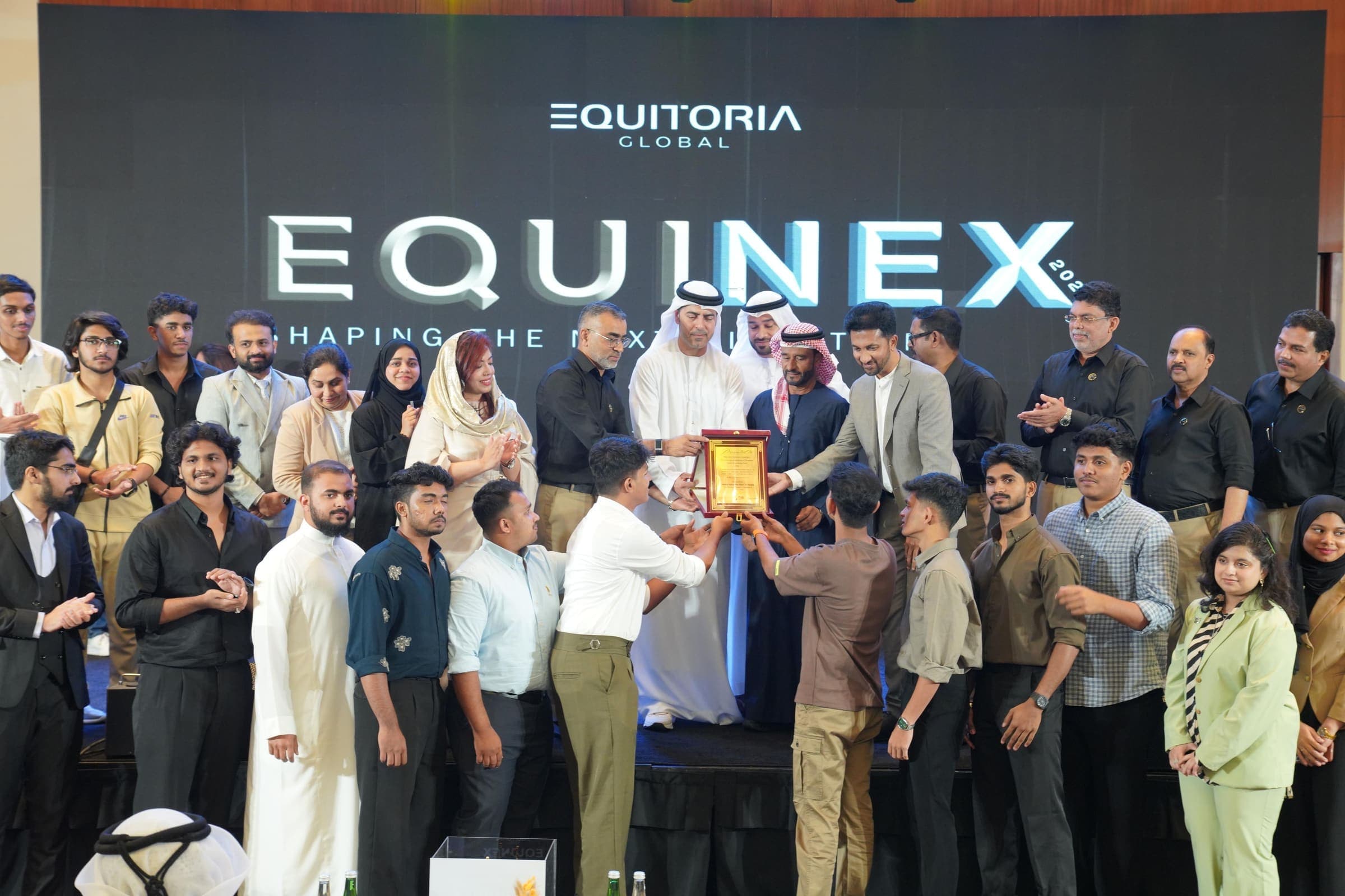 Students on stage at the Equinex industry event as a plaque is presented